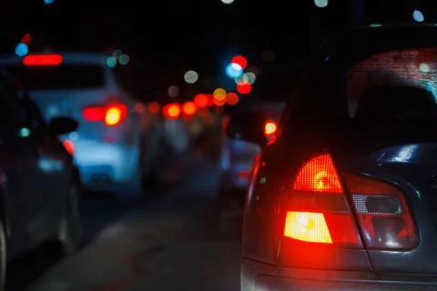 Close-up view of car tail light and right turn signal at night traffic jam Stock Photos