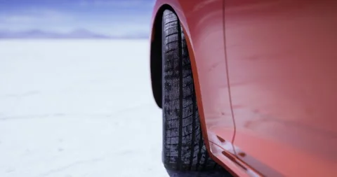 Close up view of a car tire on a salt flat during daylight Stock Footage 329176678