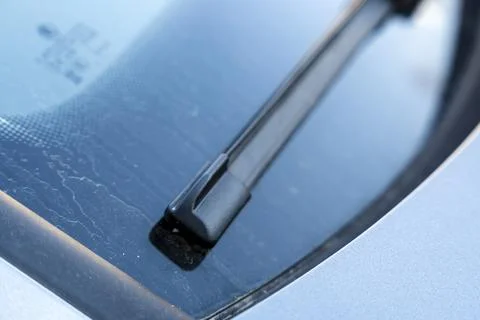 Close-up view of a car windshield wiper on a clean windshield, illustrating Stock Photos