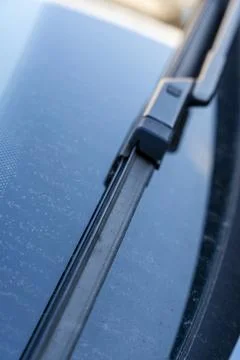 Close-up view of a car windshield wiper on a dirty windshield. The background 库存照片