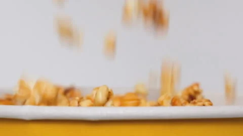 Close up view on caramel popcorn falling into paper bucket isolated on white Stock Footage 169823472