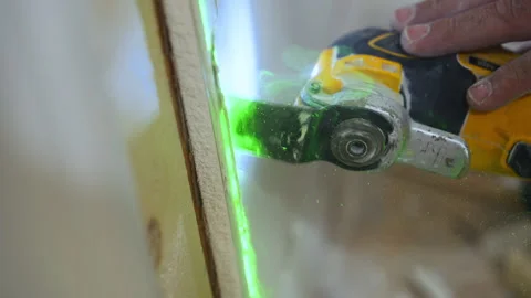 Close up view of Carpenter using an oscillating power tool to cut drywall and Stock Footage 346801855