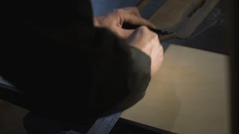 Close Up view of a carpenter using a straightedge to draw a line on a board Stock Footage 107615263