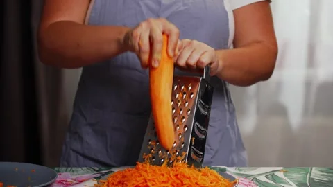 Close view of carrot grating process in home kitchen Stock Footage 343543694
