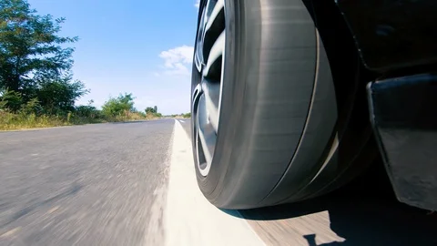 Close view of the car's tire spinning fast on the road Stock Footage