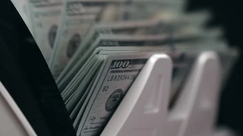 Close-up view of cash counting machine processing stacks of hundred-dollar bills Stock Footage 331080199
