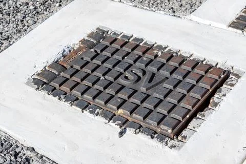 Close-up view of a cast iron stop valve access lid embedded in a road surface Stock Photos