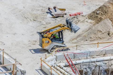 Close up view of Caterpillar compact track loader working at construction site. Stock Photos