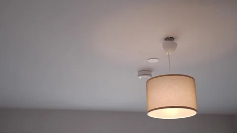 A close-up view of a ceiling light turning on and off in a modern house. Stock Footage 332747248