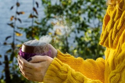 Close-up view of ceramic cup of hot coffee ortea in female hand. hot beverege Foto stock