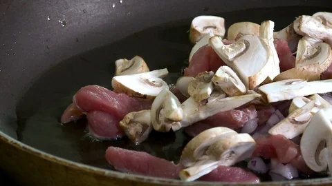 Close up view of champignon, meat and onions frying on oil . Stock Footage 119155287