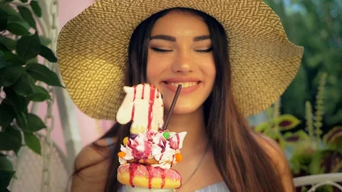 Close up view of charming girl drinking sweet multilayered milkshake. Video stock 104057270