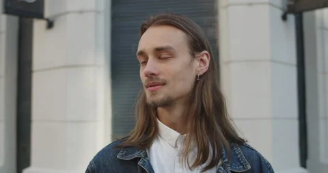 Close up view of cheerful long haired man turning head and looking to camera Video stock 136647357