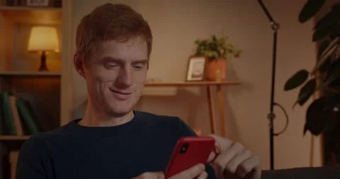 Close up view of cheerful man using smartphone while sitting on couch at home Stock-Footage 149318654