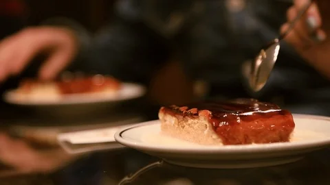 Close up view of cheesecake covered with chocolate frosting on white plate being Stock Footage 105274217