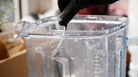 Close up view of a chef in black gloves taking out ice via spoon. Experiment Stock-Footage 99360393
