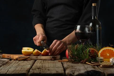 Close-up view of chef cuts apple on wooden board fore preparing mulled wine o Stock Photos