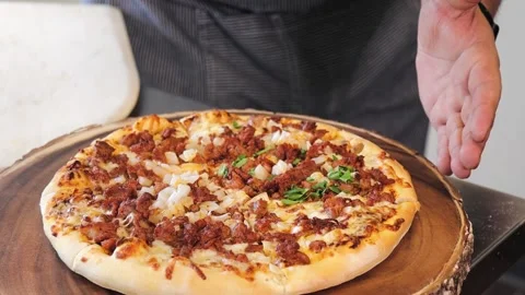 Close up view of a chef sprinkling fresh cilantro on a cooked pizza. Vídeo Stock 137530902