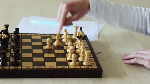 A close-up view of a chess game in progress, showing a hand moving a white pawn Stock Footage 278900125