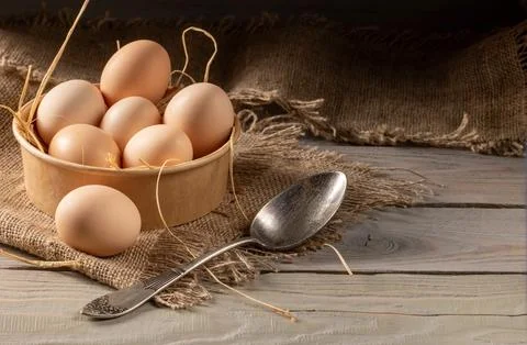 Close-up view of chicken eggs on a rustic wooden peasant table Stock Photos