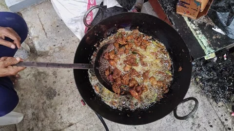 Close-up view of chicken kebabs being fried in hot oil in a large pan on a .. Vidéo 337037696