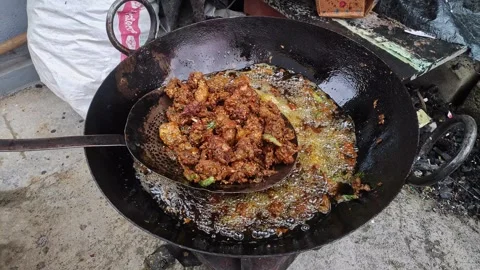 Close-up view of chicken kebabs being fried in hot oil in a large pan on a .. Vidéo 337038756