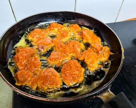 Close view of chicken pieces deep frying in pan with sizzling oil Stock-Fotos