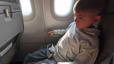 Close-up view of a child covering his face and crying.Headache in the airplane Stock Footage 315022981
