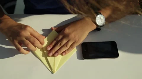 A close view of a child hands making origami of yellow paper at school. 库存影片 62779413