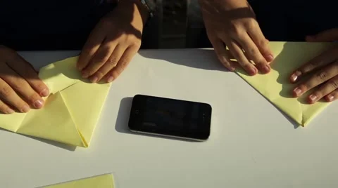A close view of a child hands making origami of yellow paper at school. 库存影片 62779444