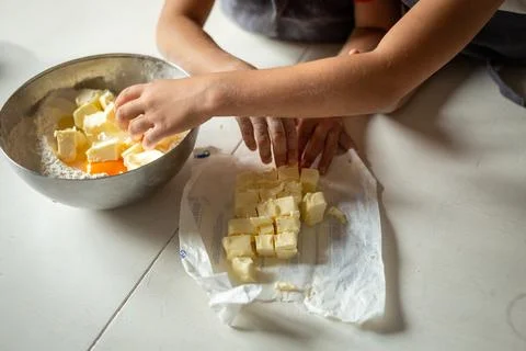 Close view of children hands adding butter to flour 스톡 사진