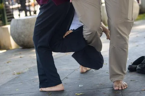 Close up view of children interlocking legs in traditional balance game din.. Stock Photos