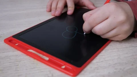 Close-up view of childs hands drawing a flower on a red doodle board Stockbeeldmateriaal 270814953