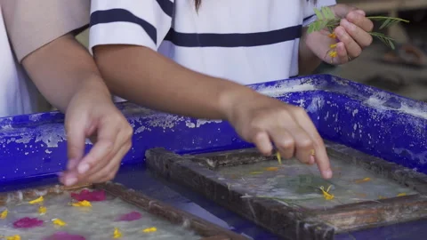 A close-up view of a child's hands traditionally making handmade mulberry paper. Stock-Footage 329925238