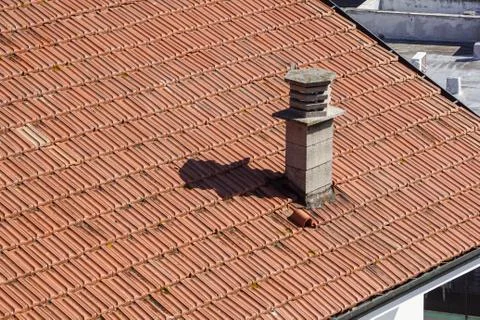 A close up view of a chimney on top of red roof tiles Stock Photos