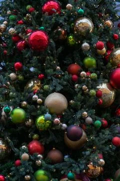Close up view of Christmas tree branch with decorative balls, toys and shining Stock Photos