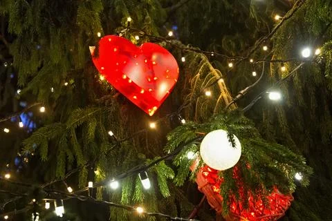 Close up view of the Christmas tree branches with shining toys in the shape.. Stock Photos
