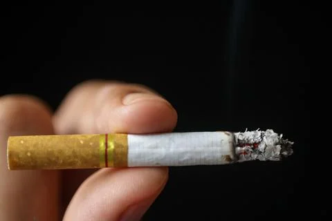 Close up view of a cigarette being held by a person with two fingers illustra Stock Photos