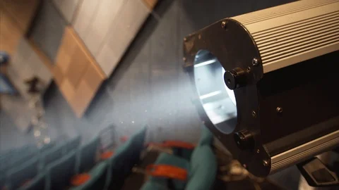 Close view of cinema spotlight and dust floating in the air seen at light Vídeo Stock 121303346