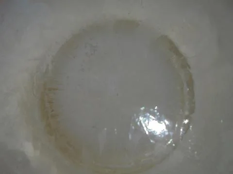 Close view on circle in transparent ice formed around dense white ice crystal. Stock Photos