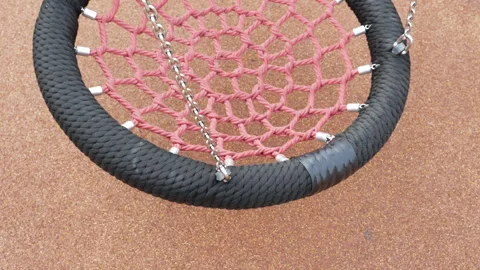 Close up view of a circular rope nest swing hanging still in an outdoor play Stock Footage 336847838