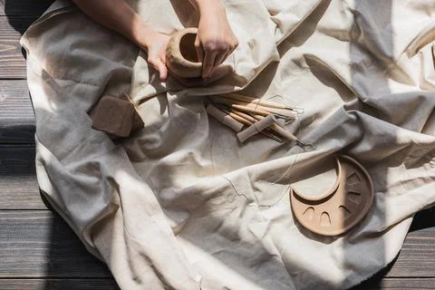 A close-up view of clay plates and a paint brush on a wooden table and dried Stock Photos