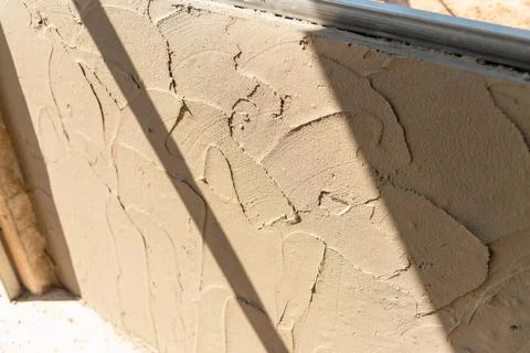 Close-up view of clay wall installation craftsmanship in sunlit constructio.. Stockfoto's