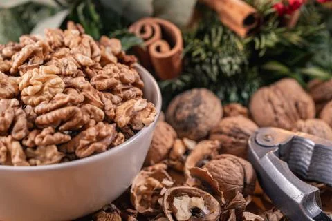 Close up view of clean walnut kernels in a bowl, a nutcracker and scattered n Stock Photos
