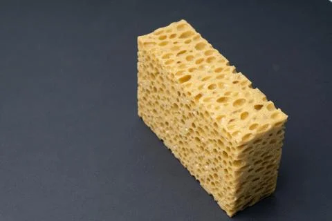Close up view of cleaning sponge, mesh structure pattern on black surface Stock Photos