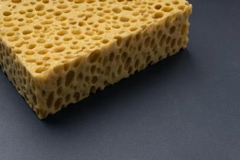 Close up view of cleaning sponge, mesh structure pattern on black surface Stock Photos