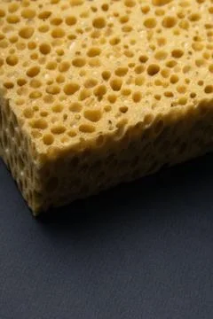 Close up view of cleaning sponge, mesh structure pattern on black surface Stock Photos