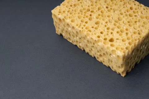 Close up view of cleaning sponge, mesh structure pattern on black surface Stock Photos