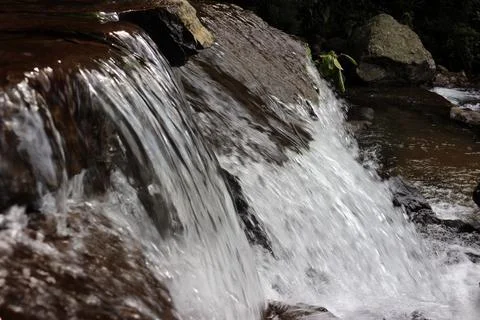 Close-up view of clear water cascading down river rocks Fotos Stock