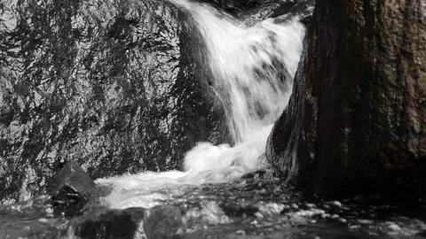 Close-up view of clear water cascading down river rocks Fotos Stock